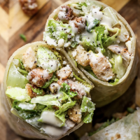 Screenshot 2026-02-11 at 11.06.14 AM Chicken caesar salad in a wrap served with fries.